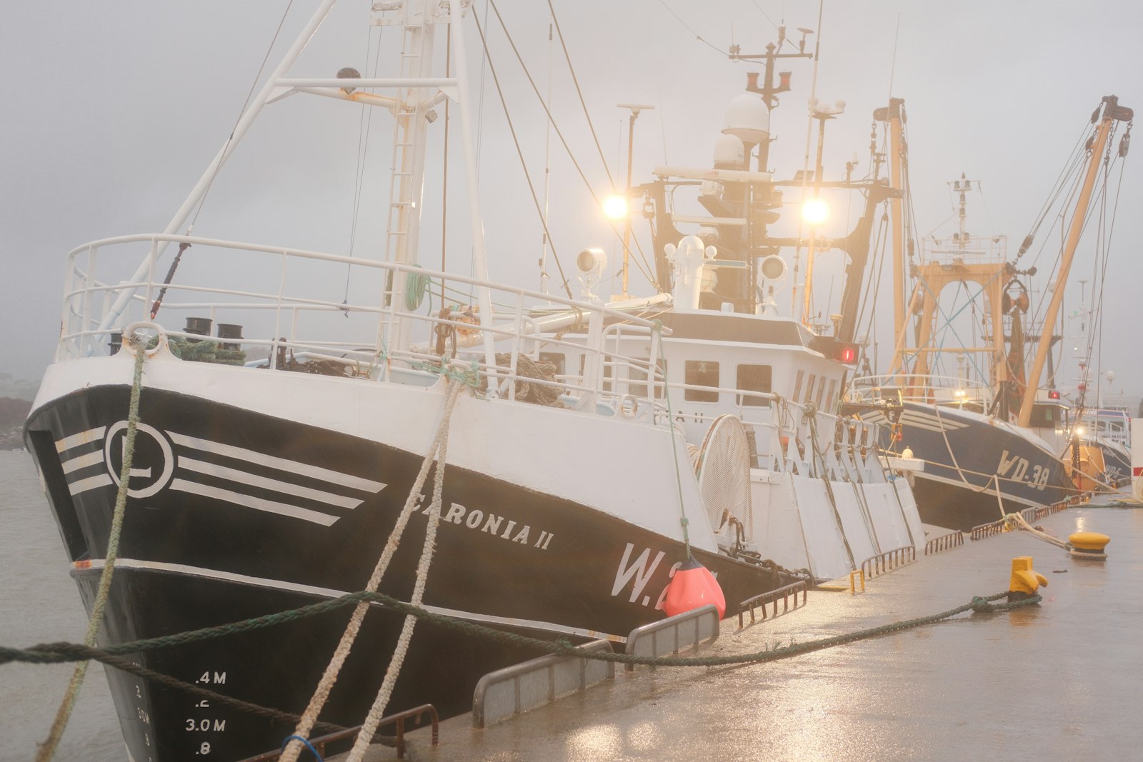 Fishing trawler docked in a misty harbor